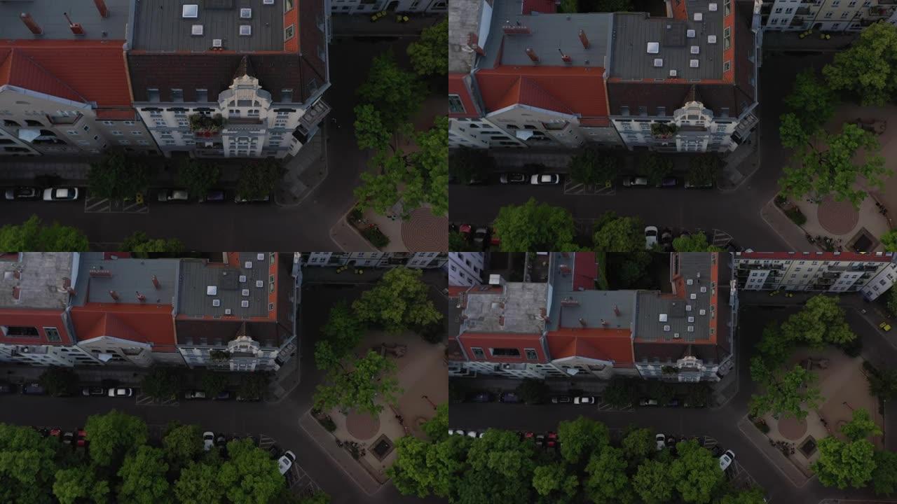 空中鸟瞰头顶上向下上升的多层唐楼和停放汽车的街道。住在城市社区。德国柏林