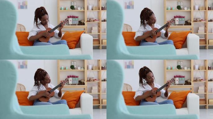 女人喜欢学弹尤克里里。用乐器练习歌曲。非洲的年轻女子