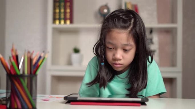 亚洲小女孩在平板电脑上看动画片，小孩使用数字平板电脑