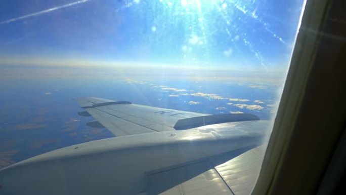 飞行过程中窗户中的太阳和飞机机翼