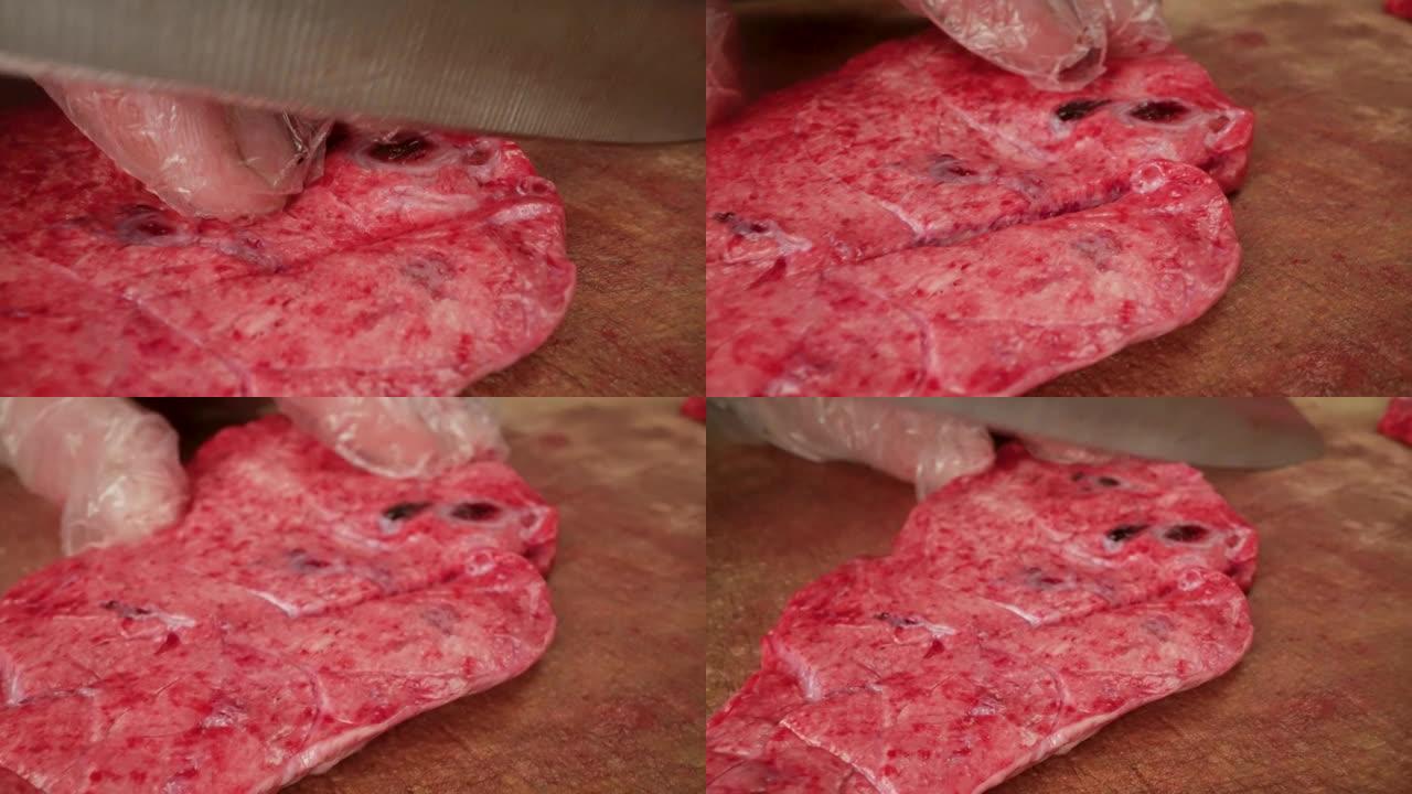 屠夫割肉的特写手-肺。切肉刀的特写