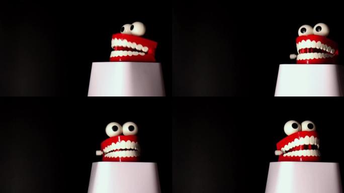 微笑的玩具假肢，白色的牙齿和大眼睛在黑色背景下隔离。