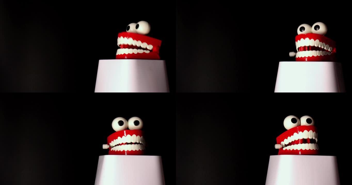 微笑的玩具假肢，白色的牙齿和大眼睛在黑色背景下隔离。