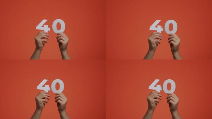 手中有40号。显示数字的人，40个由雕刻纸制成的数字，用于投票或数学学习