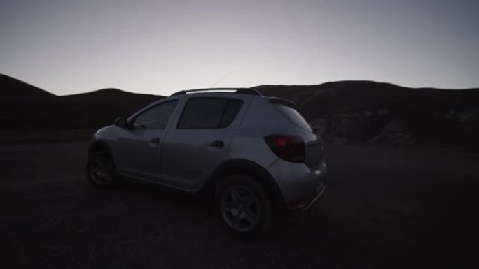 汽车的向前跟踪镜头朝相反的方向转弯。银色汽车开走的夜景。摩洛哥、非洲