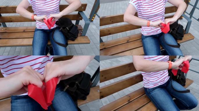 女人坐在长凳上，用阻力带运动，她总是把它放在包里