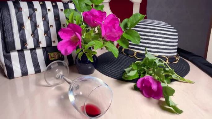 条纹帽子，桌子上有条纹的黑白钱包。红酒酒杯。现代时尚风格