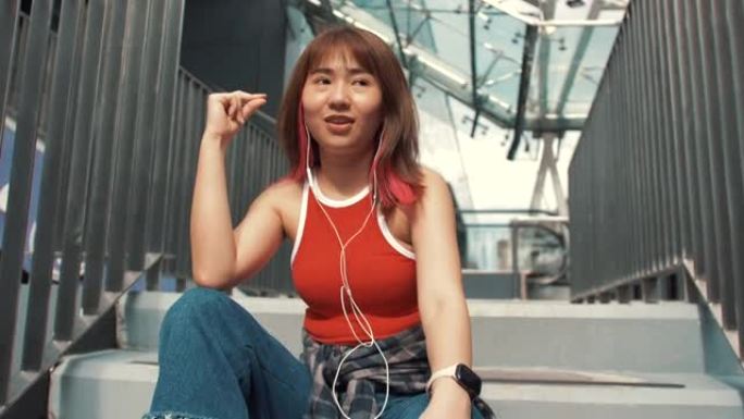 亚洲潮女在城市听音乐时跳舞