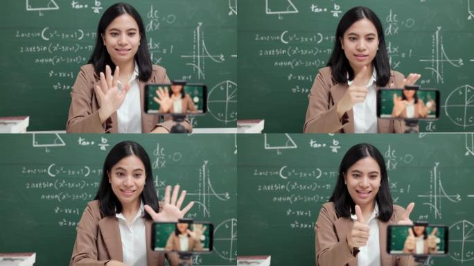 年轻的亚洲教师妇女坐和与学生的视频会议。女教师通过智能手机在线课程从直播中培训课堂数学。
