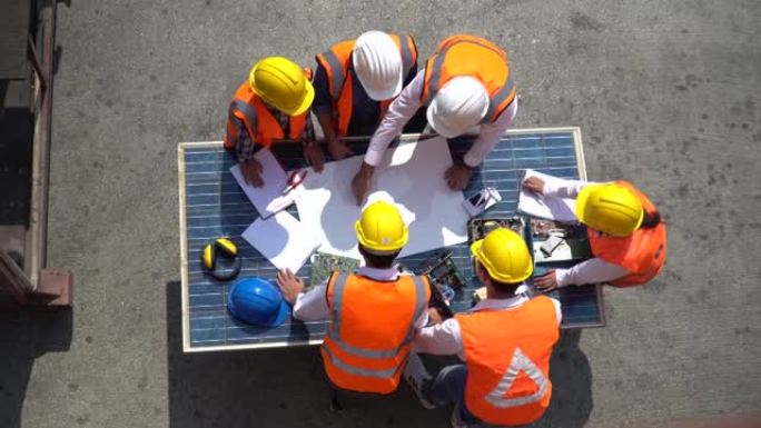 太阳能发电厂工程师小组会议和讨论，以集思广益，讨论太阳能电池顶层表规划的蓝图，以规划室外施工现场的环