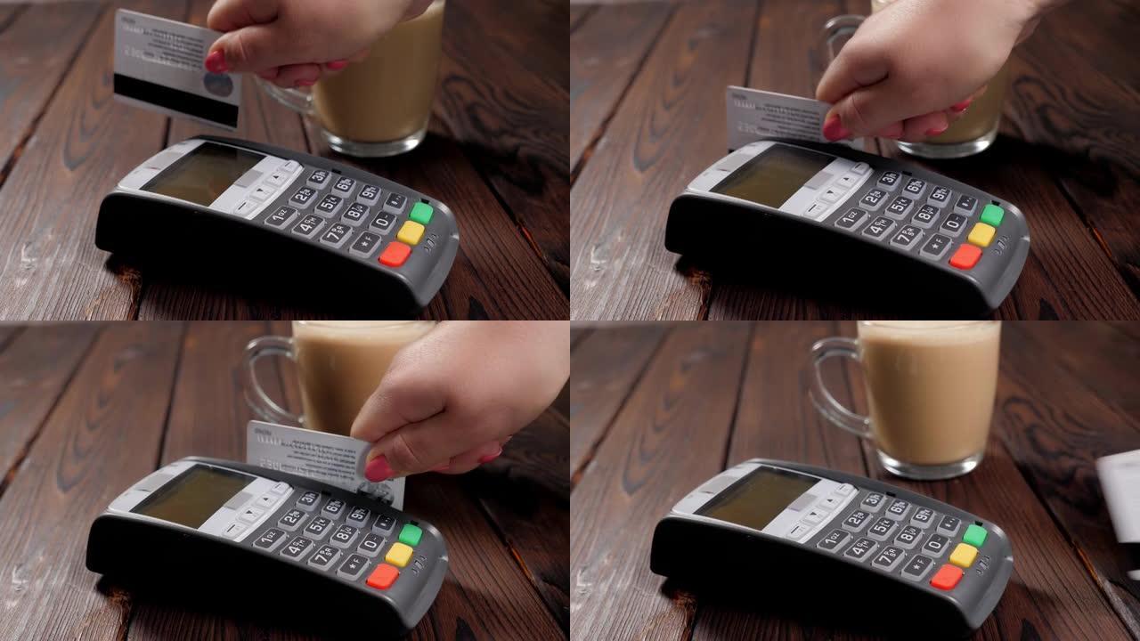 一个女人用信用卡在咖啡馆里喝咖啡的特写镜头。
