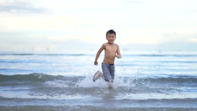 亚洲孩子在海滩上慢动作散步和跑步。自由和假期的概念