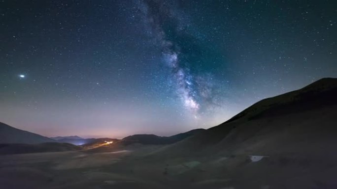 延时: 意大利诺尔西亚高地城堡上空的夜空。银河系和恒星的表观运动，在亚平宁山脉的视点。木星行星
