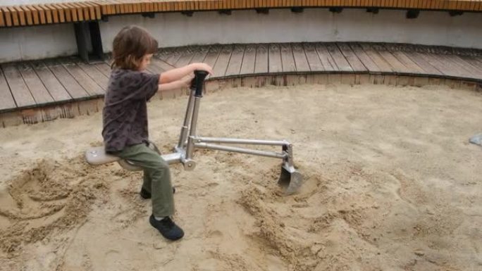 感兴趣的学龄前男孩用小型金属挖掘机挖掘