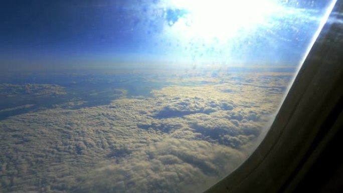 太阳和云彩穿过飞机的窗户