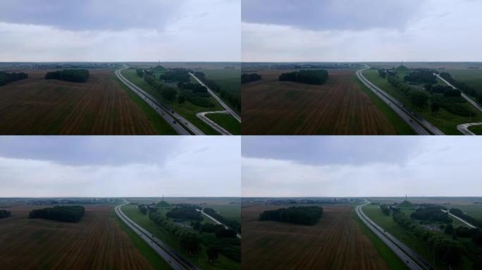 道路和运输的鸟瞰图。人们在高速公路上开车旅行。背景上的白俄罗斯荣耀纪念碑。戏剧性的天空。物流和旅行概
