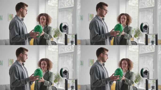 才华横溢的男女夫妇在家里用3D打印机制作的手中的灯罩中