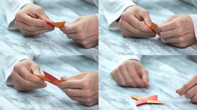 手做四个尖的手里剑折纸。