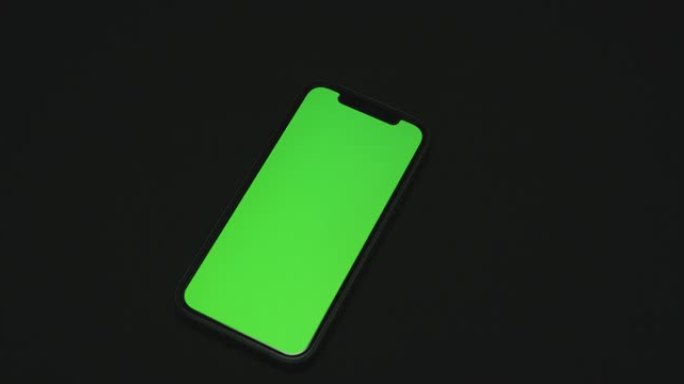 绿屏手机在黑色表面上放下