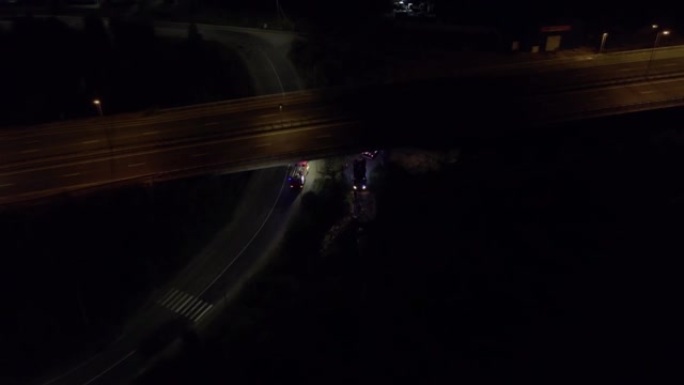 消防车消防水带准备在夜间灭火桥下警笛高架桥顶部的闪光灯正在驾驶汽车鸟瞰图