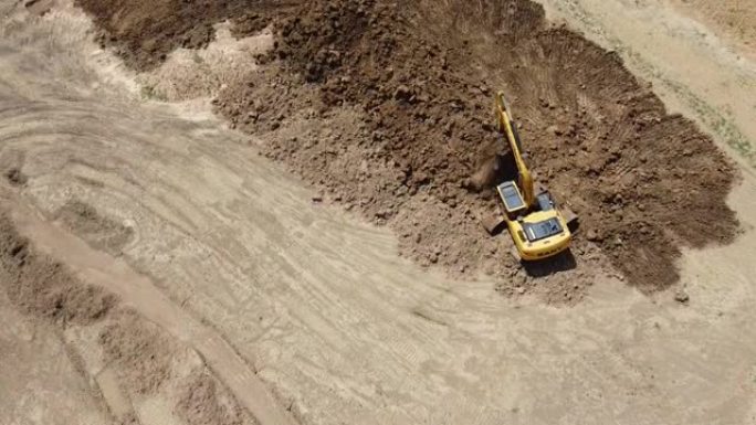 4K在反铲挖土机或挖掘机上通过无人机从鸟瞰图刮擦土壤层