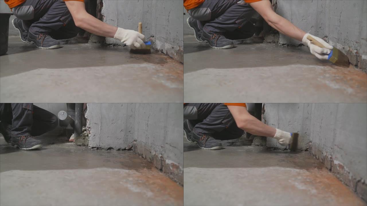 工人用水涂抹混凝土地板进行加工。防水混凝土地板。工人在给地板防水之前做了一个初步步骤