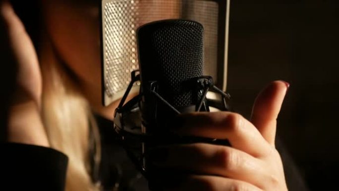 一位歌手在录音室录制曲目的特写镜头。