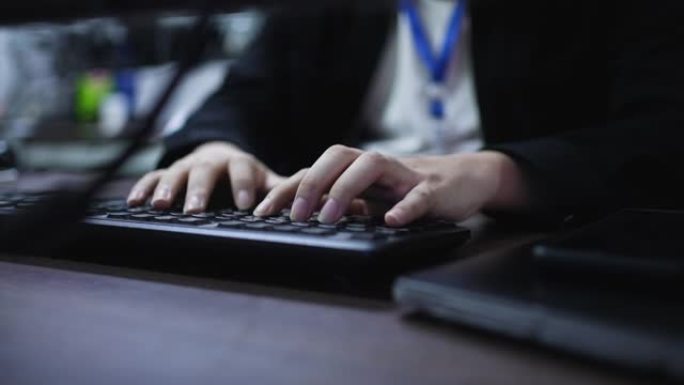程序员的慢动作场景在台式电脑上用手在键盘上打字，以在夜间在办公室修理或检查任务，以解决过度工作的概念