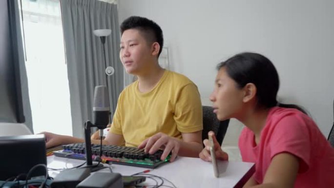 快乐的亚洲儿童在家里一起玩网络游戏时直播，新一代生活方式的时尚活动