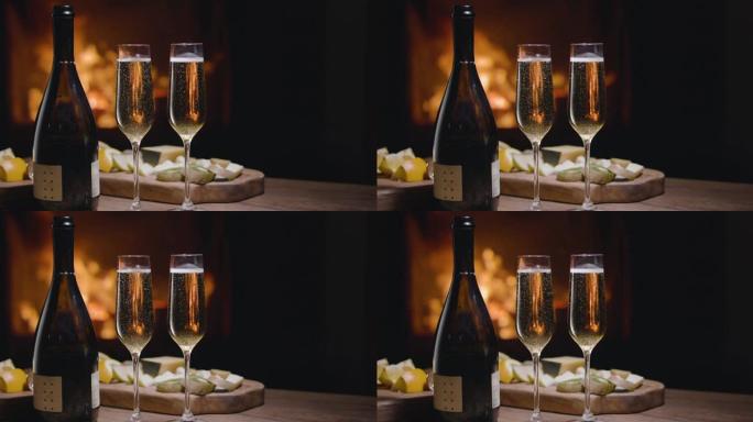 两杯香槟中的气泡慢慢向上上升。壁炉里的火在后面燃烧。浪漫晚餐。慢动作150fps，黑魔法Ursa P