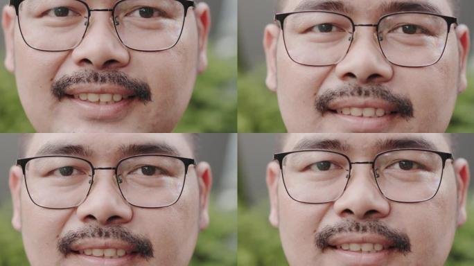 戴着眼镜和小胡子微笑着自信享受成功的迷人亚洲男人的特写肖像。看着相机开心。男性积极思考。肥胖人群健康