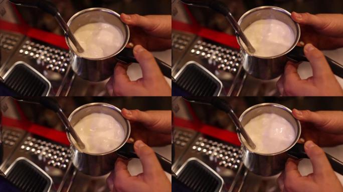 使用浓缩咖啡机在金属玻璃瓶中蒸牛奶
