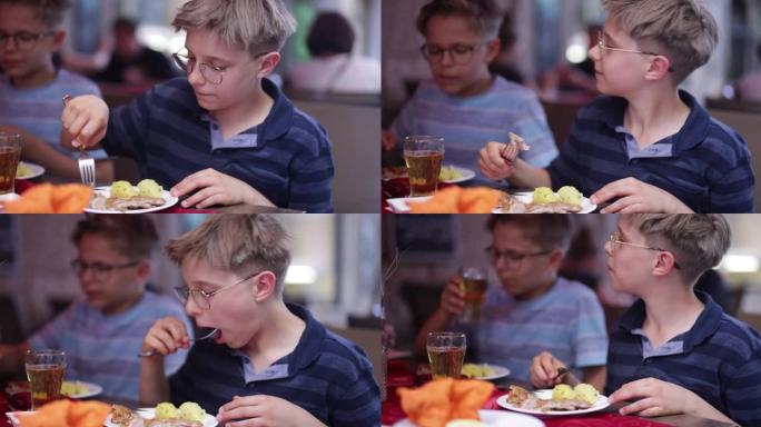 小男孩在餐厅享用维也纳炸肉排午餐