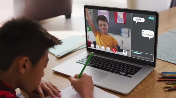 亚洲男孩在家里做作业并与笔记本电脑上的同学进行视频通话
