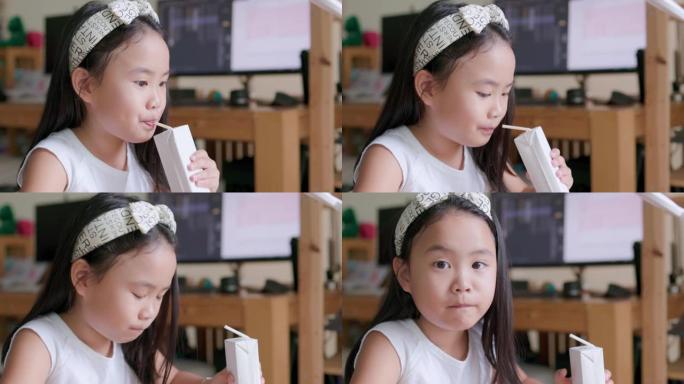 一个年轻的女孩高兴地喝了一盒白色的牛奶。