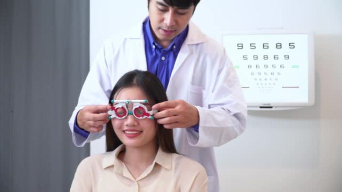 验光师男子测试视力测试用视力表，Snellen图和可调瞳孔间距离试验框架，用于亚洲年轻女性的视力，具