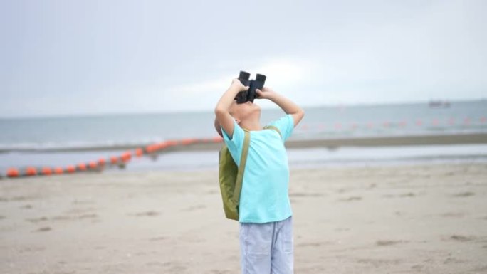 亚洲孩子用双筒望远镜和放大镜在海滩上学习户外