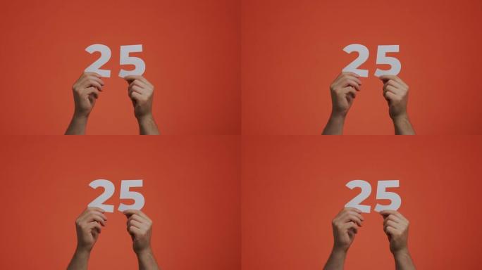 25号在手。显示数字的人，25个由雕刻纸制成的数字，用于投票或数学学习