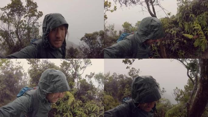 恶劣天气下在雨林徒步旅行的人。冒险的人在远足自拍风格的拍摄中