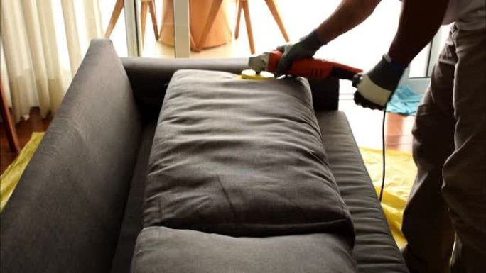 专业使用带刷子的电动抛光机清洁沙发垫。
