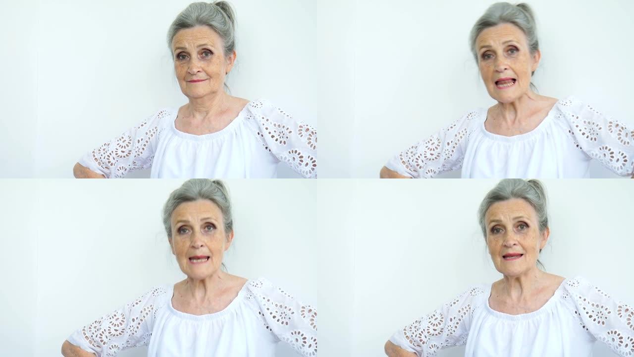 美丽的老奶奶白发，满脸皱纹，看着白色背景上的相机，母亲节，退休快乐