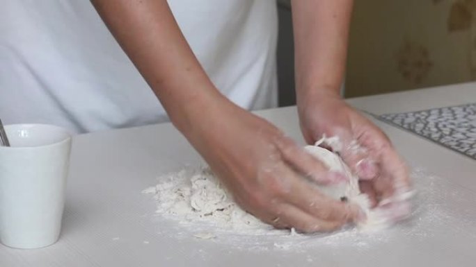 一个女人揉面团做饺子。在桌子的表面上。用土豆和肉末煮饺子。特写镜头。