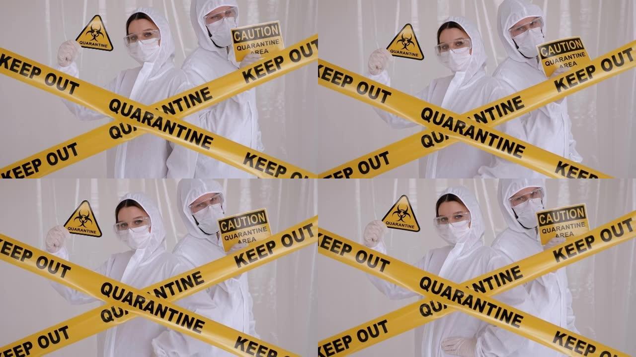 两名医生穿着防护服，在实验室里举着“注意隔离区”的牌子