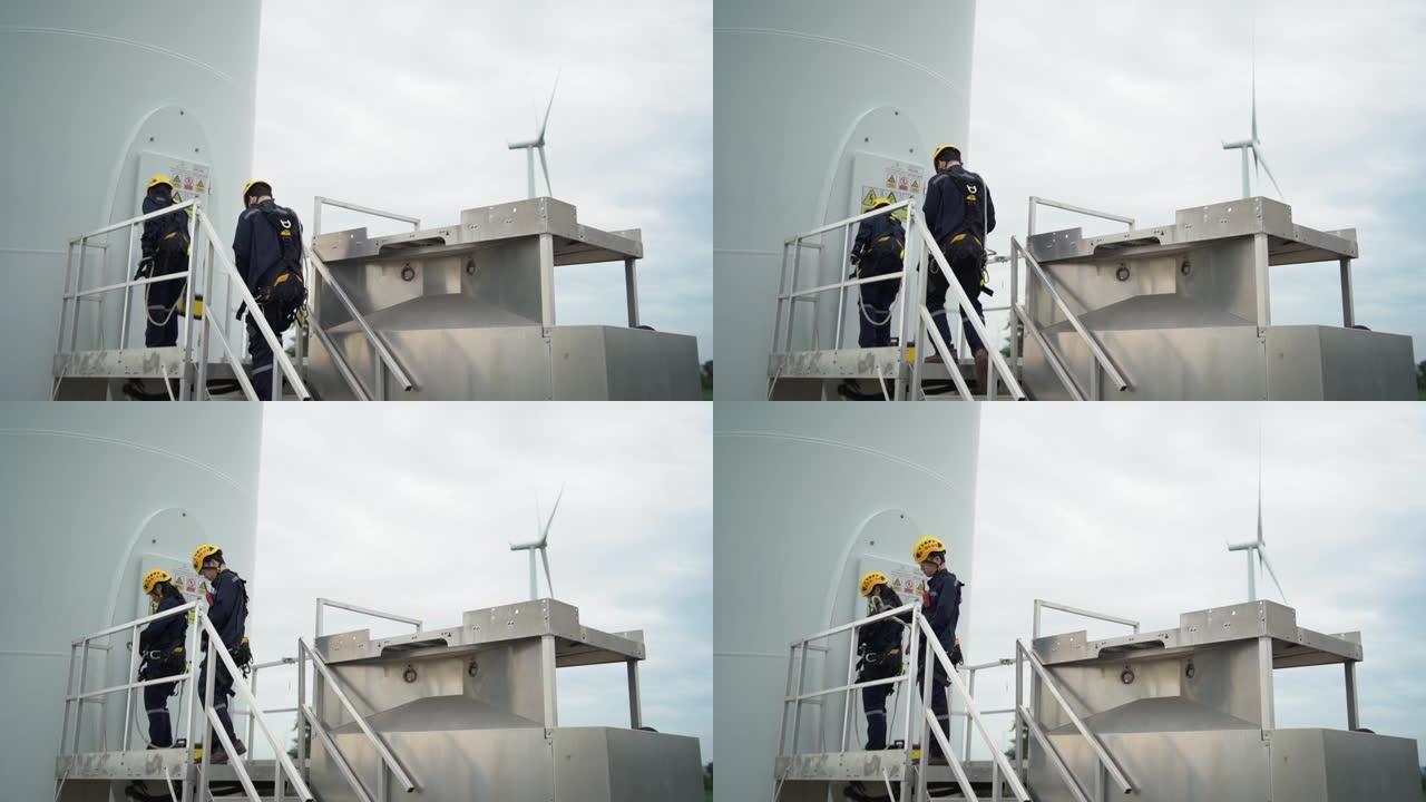 两名亚洲工程师在统一检查工程师的准备和进度检查在泰国风电场中的风力涡轮机的安全性。