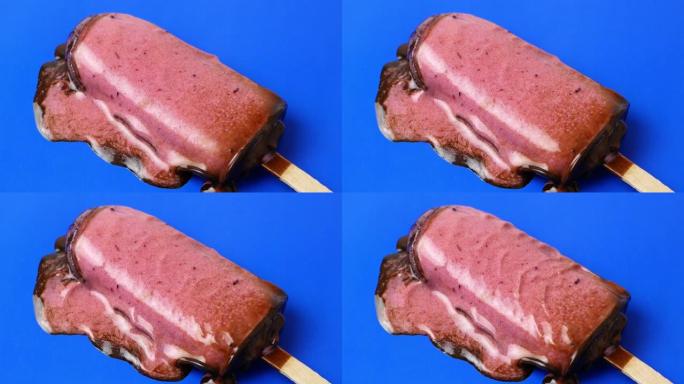 巧克力冰淇淋圣代躺在蓝色背景上，融化缓慢。4k视频美食特写。