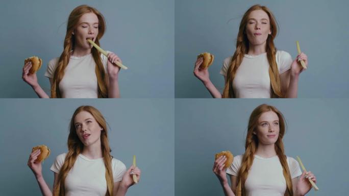 在决策过程中，在工作室里，红头发和雀斑的姜女人在拿着汉堡包的同时咬着韭菜