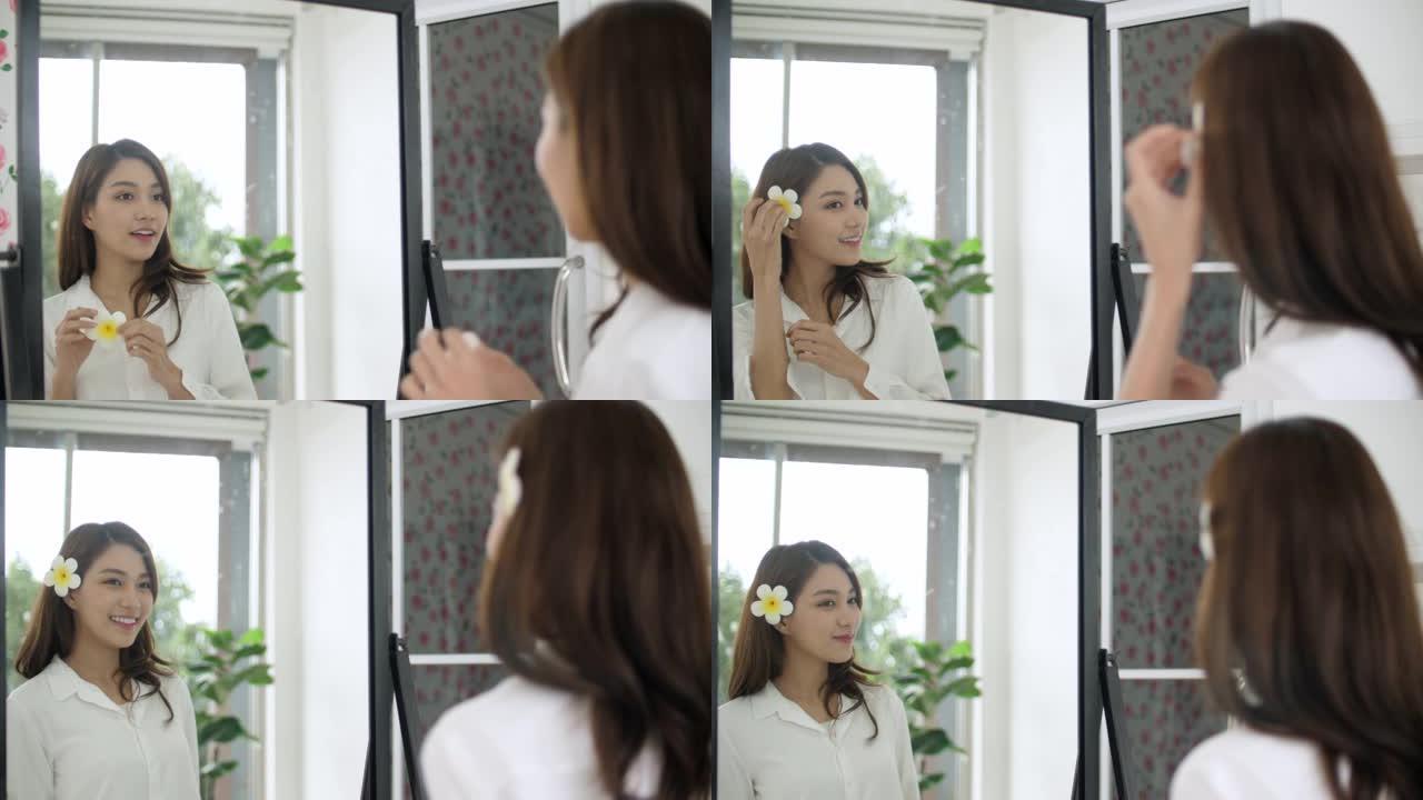 美丽的年轻亚洲女子在镜子前化妆
