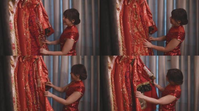 亚洲中国美女在中国传统精品店的服装架上选择旗袍