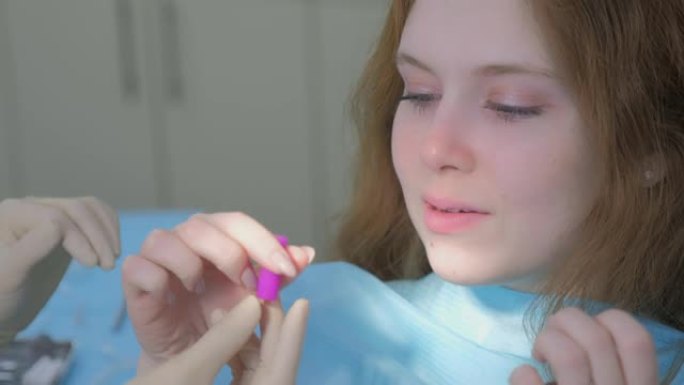 正畸医生在女孩的牙齿上安装硅胶透明牙套。