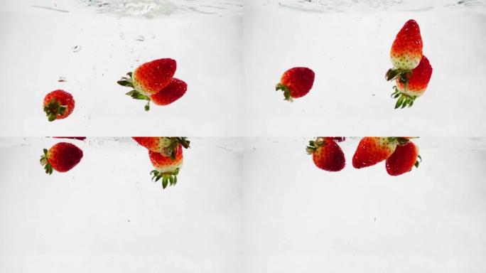 草莓在水中落下并旋转。白色孤立背景上的慢动作。